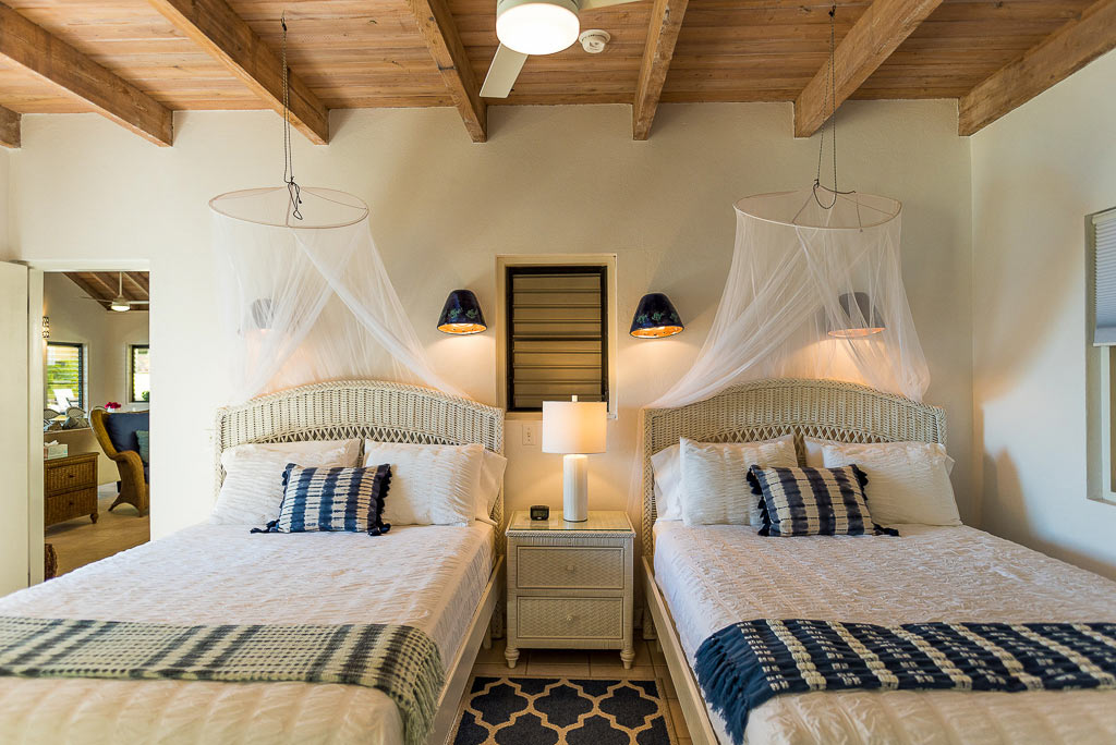 A Dream Come True Villa’s bright double bedroom with twin beds and a natural wood-beam ceiling with a ceiling fan.