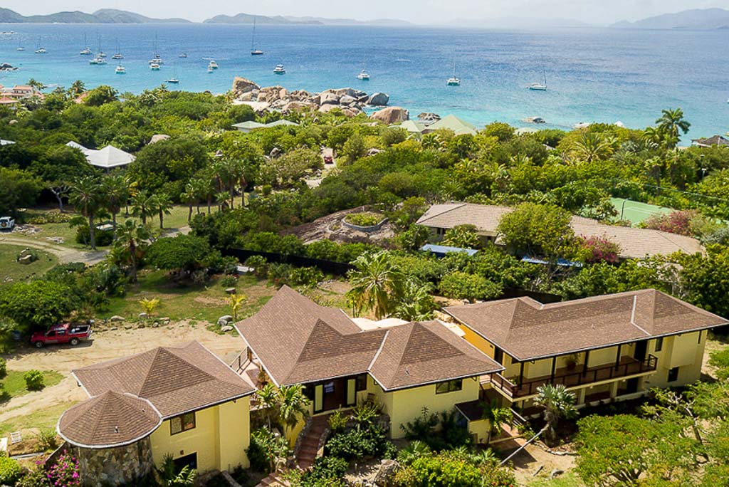 Cornucopia Villa in a green, tropical setting at Little Trunk Bay with the blue Caribbean water and sailboats in the distance.