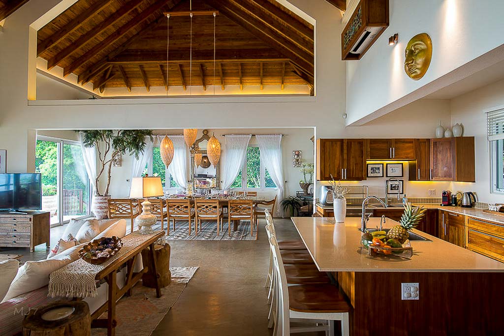 La Vida Villa’s airy great room with lofted ceilings, stone floors and separate kitchen, dining and living areas.