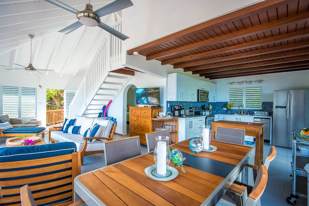 Main room of Sea View Villa with a clean and bright modern design, lofted ceilings and areas for cooking, sitting and dining.